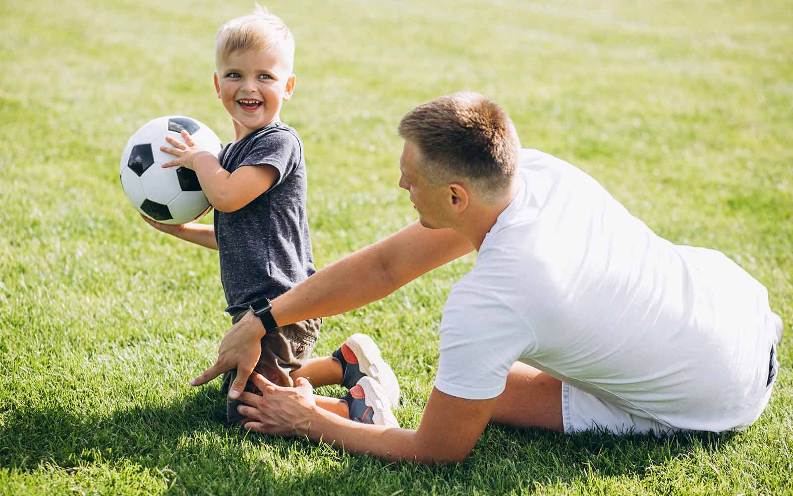 boy playing football with dad