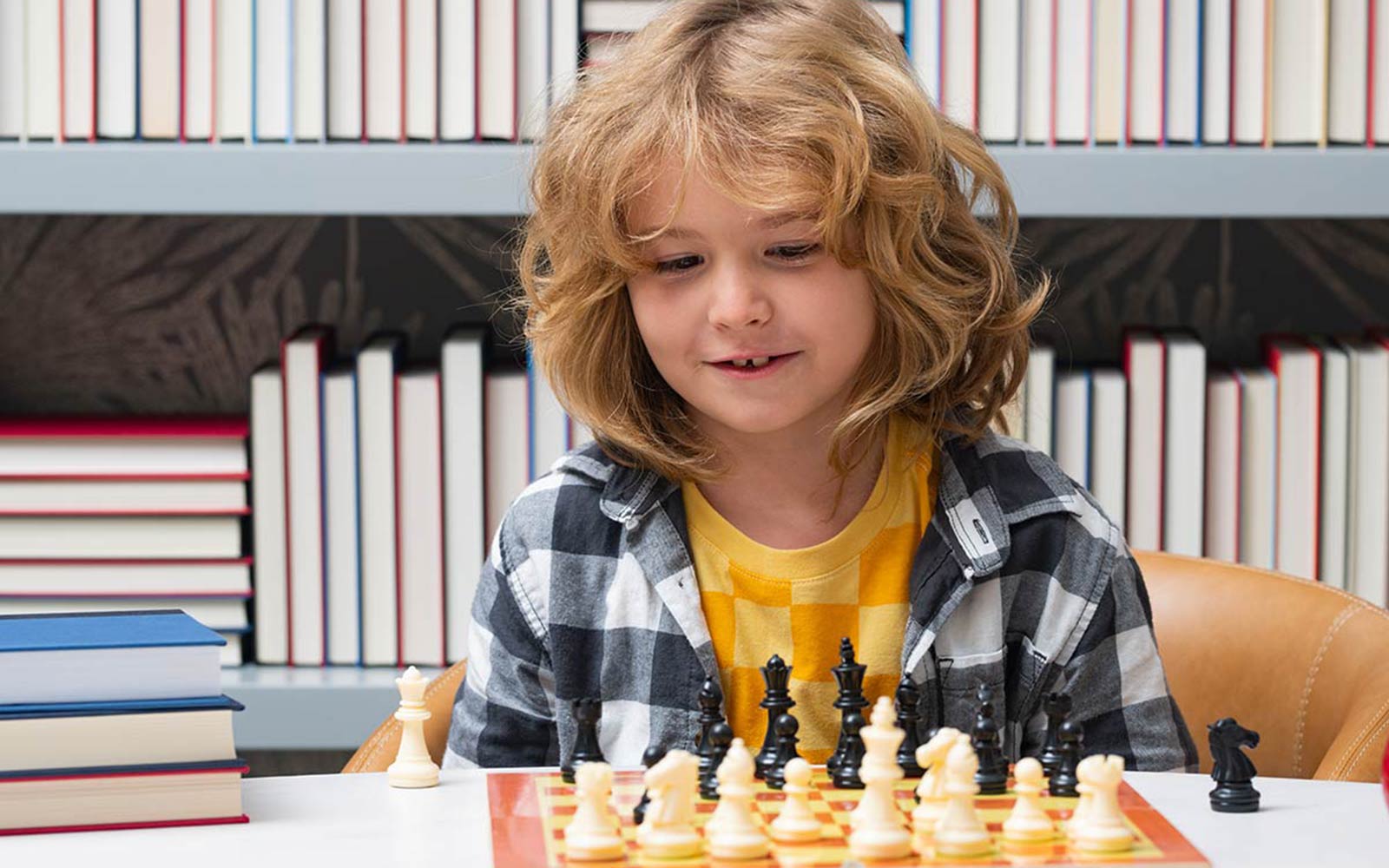 child smiling while playing chess
