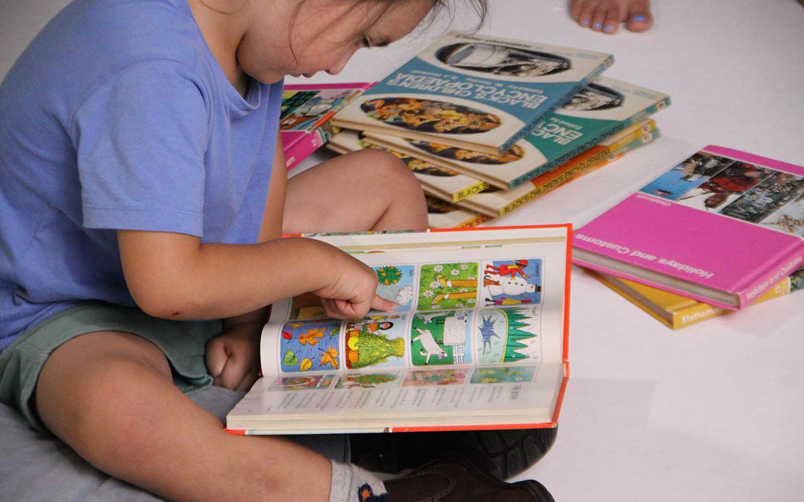 child concentrating on reading picture book