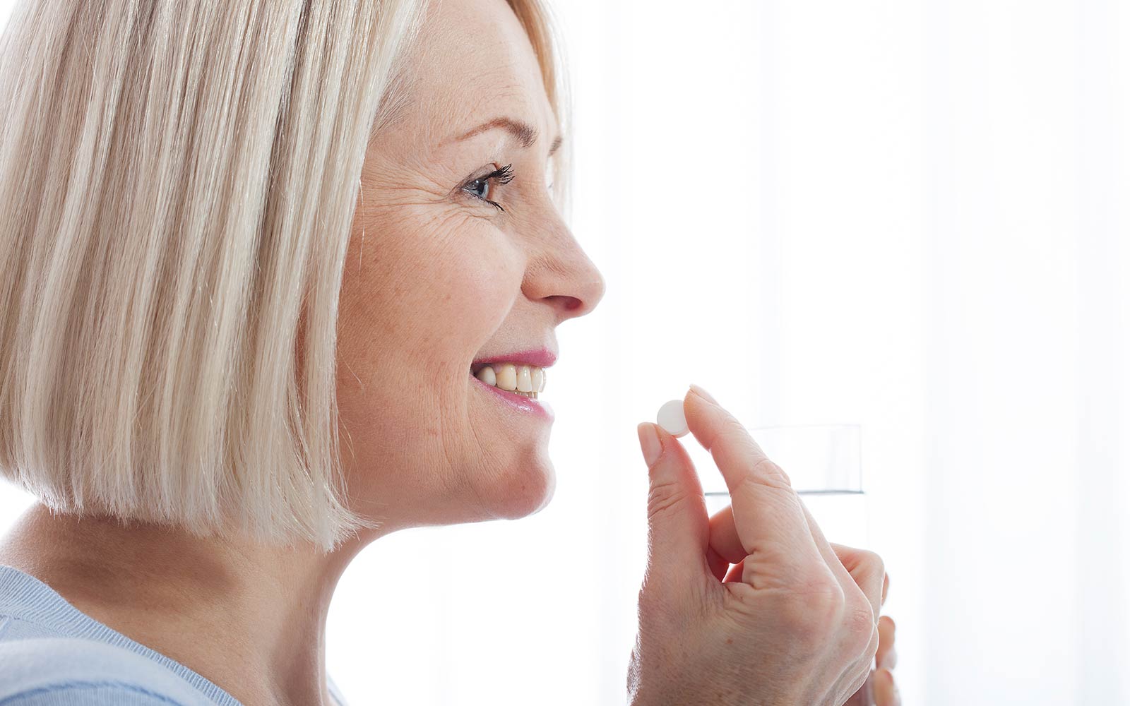 Smiling woman ingesting pill